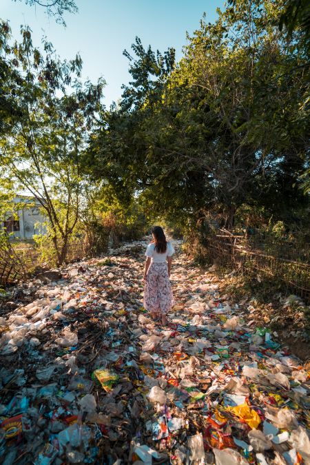 Foto de mujer de pie en una montaña de basura